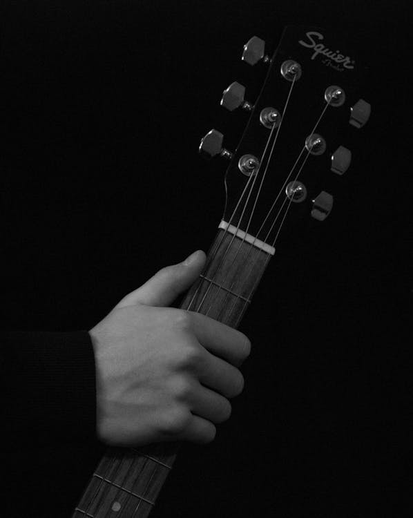 Person Holding Black Squier Fender Guitar