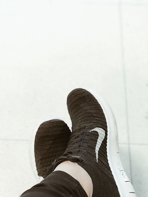 Fotomural Primer plano de zapatillas de punto negras en el pavimento, mostrando calzado de moda casual.