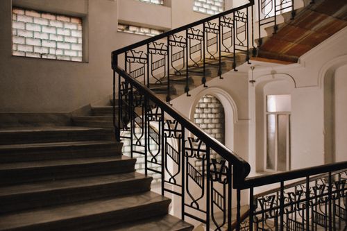 Free Interior shot showcasing a classic staircase with ornate iron railings and geometric patterns. Stock Photo