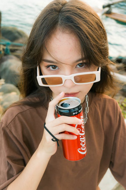 Woman Wearing White Sunglasses Holding a Can of Soda