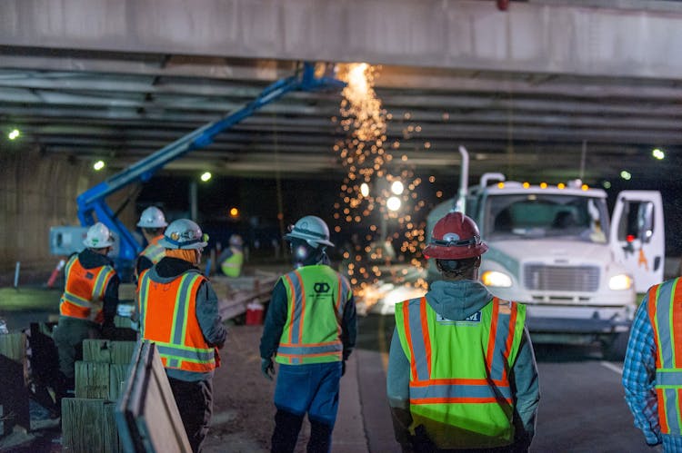 Construction Workers On The Road At Night