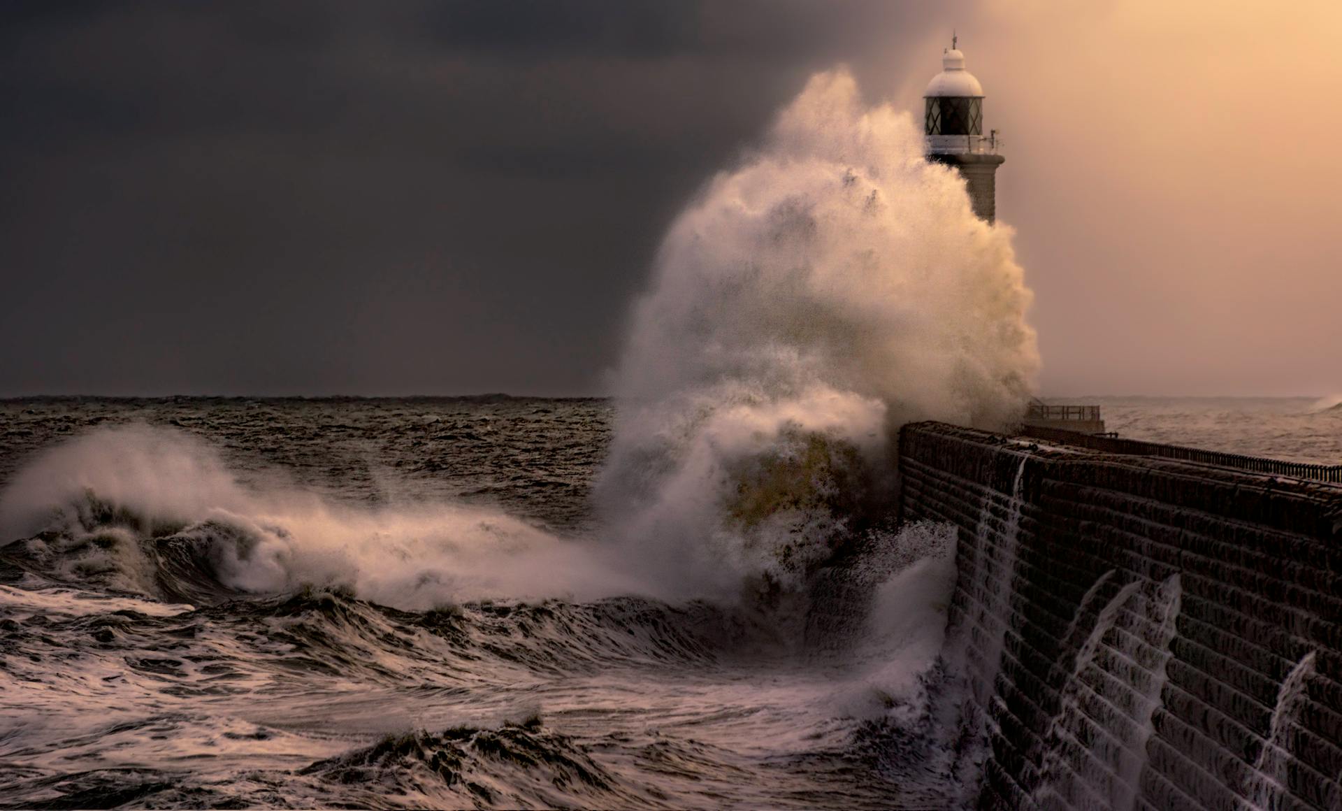 Powerful waves crash against a lighthouse in a dramatic ocean scene, capturing the raw beauty of nature.