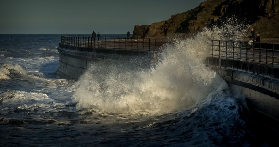 waves crashing over coastal breakwater