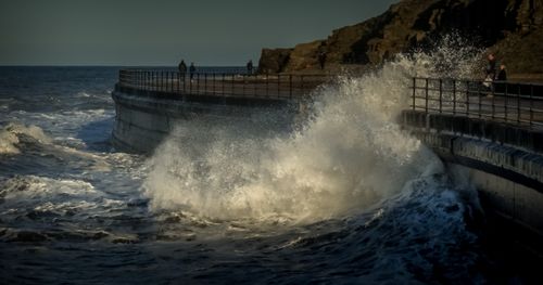 Free Powerful ocean waves crashing against a seawall with a dramatic background. Stock Photo