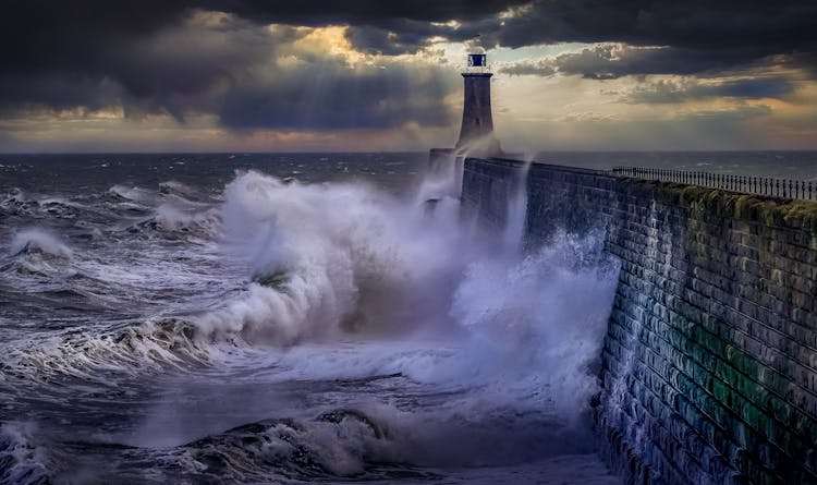 Waves Crashing On Wall With Lighthouse