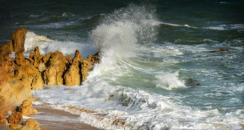 Free Powerful ocean waves crashing onto rugged rock formations creating a dynamic seascape view. Stock Photo