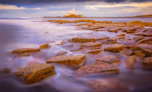 Free A tranquil view of St Mary's Lighthouse with long exposure, capturing the serene coast at sunset. Stock Photo