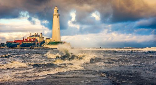 Free Dramatic seascape of St Mary's Lighthouse with crashing waves in Whitley Bay, England. Stock Photo
