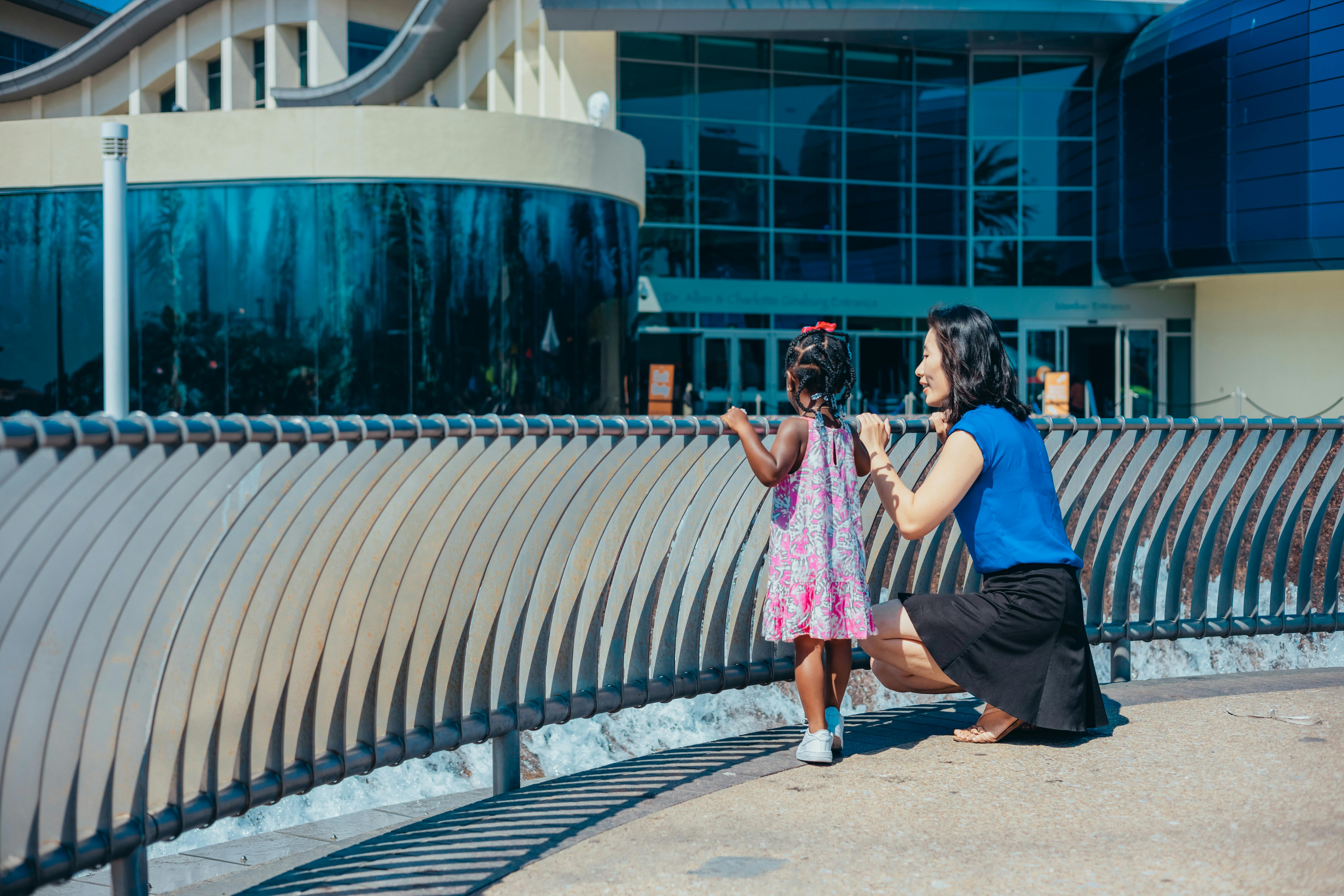 a mother and child holding on metal railing