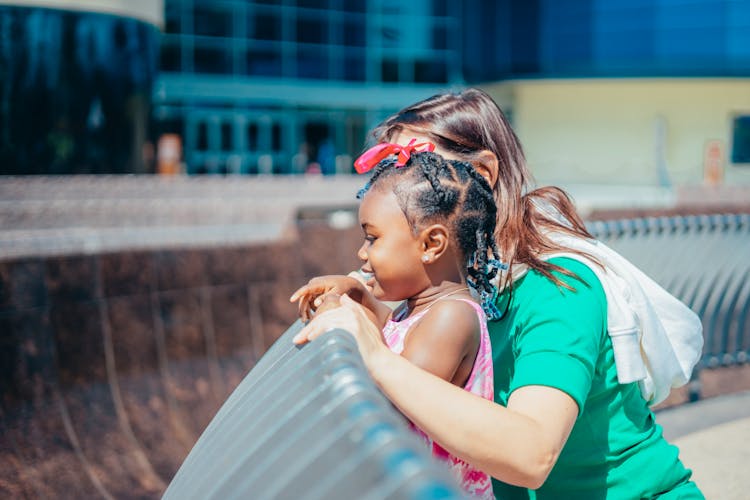 A Woman And A Young Girl Close Together