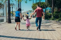 Man in Red Tank Top and Blue Denim Shorts Holding Girl in Pink Dress