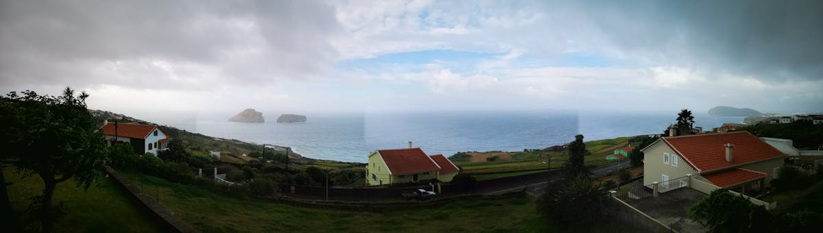 Person studying at a desk with headphones on, laptop open, and warm ambient lighting