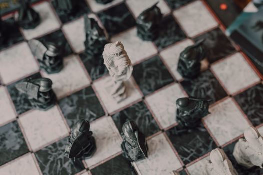 Artistic top-down photo of a decorative chessboard with unique chess pieces, emphasizing strategy and focus.
