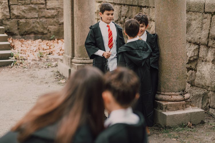 Boys In Black Robes Holding Wands