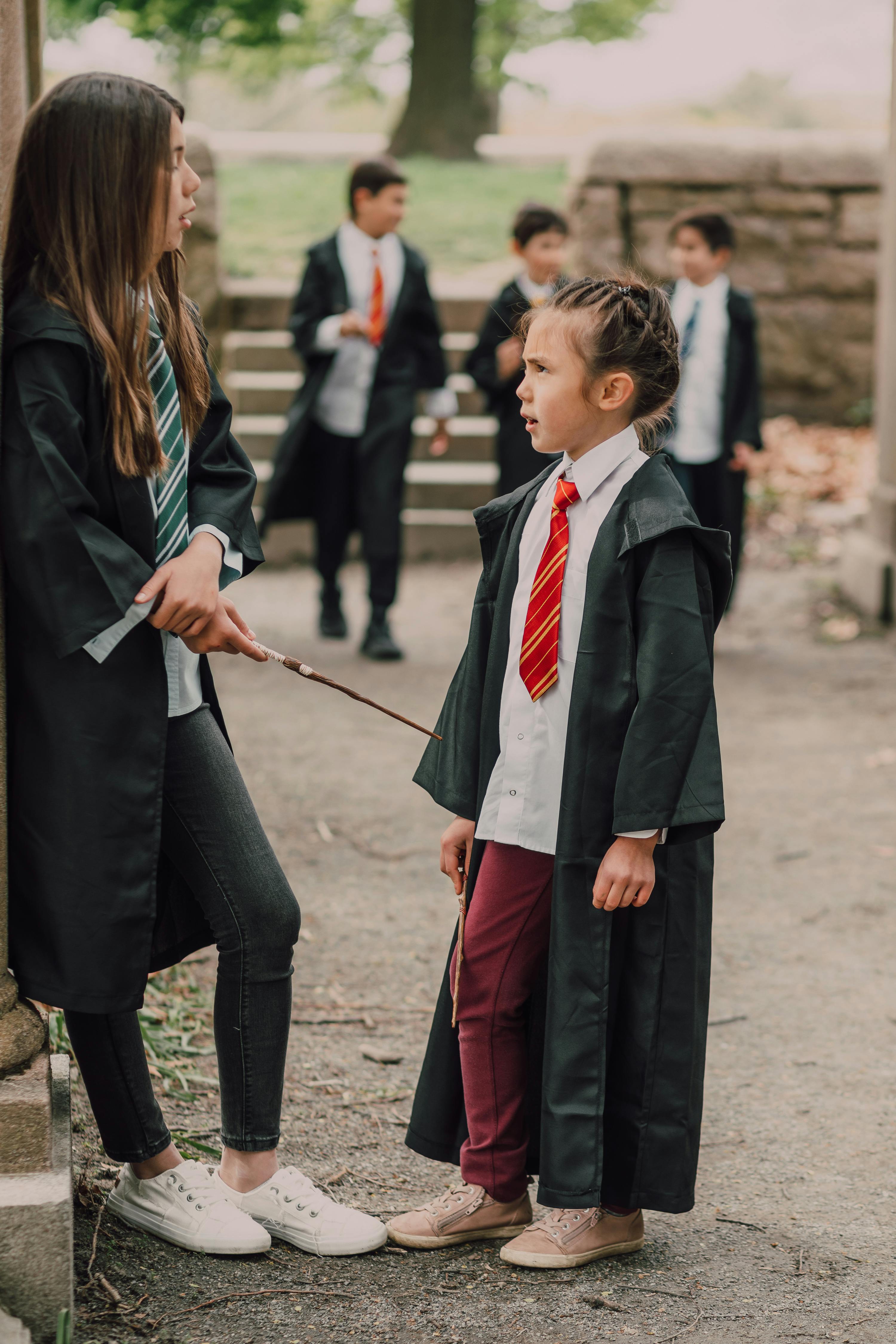 girls in black robes holding wands