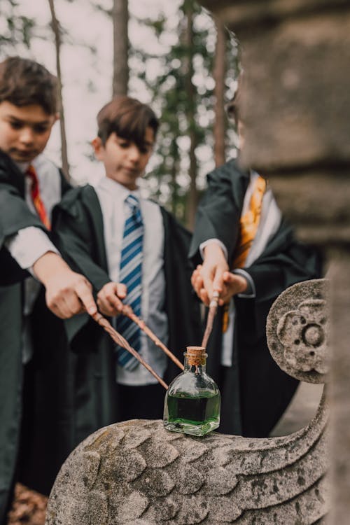 Free Kids Wearing Harry Potter Costumes Holding Magic Wands  Stock Photo