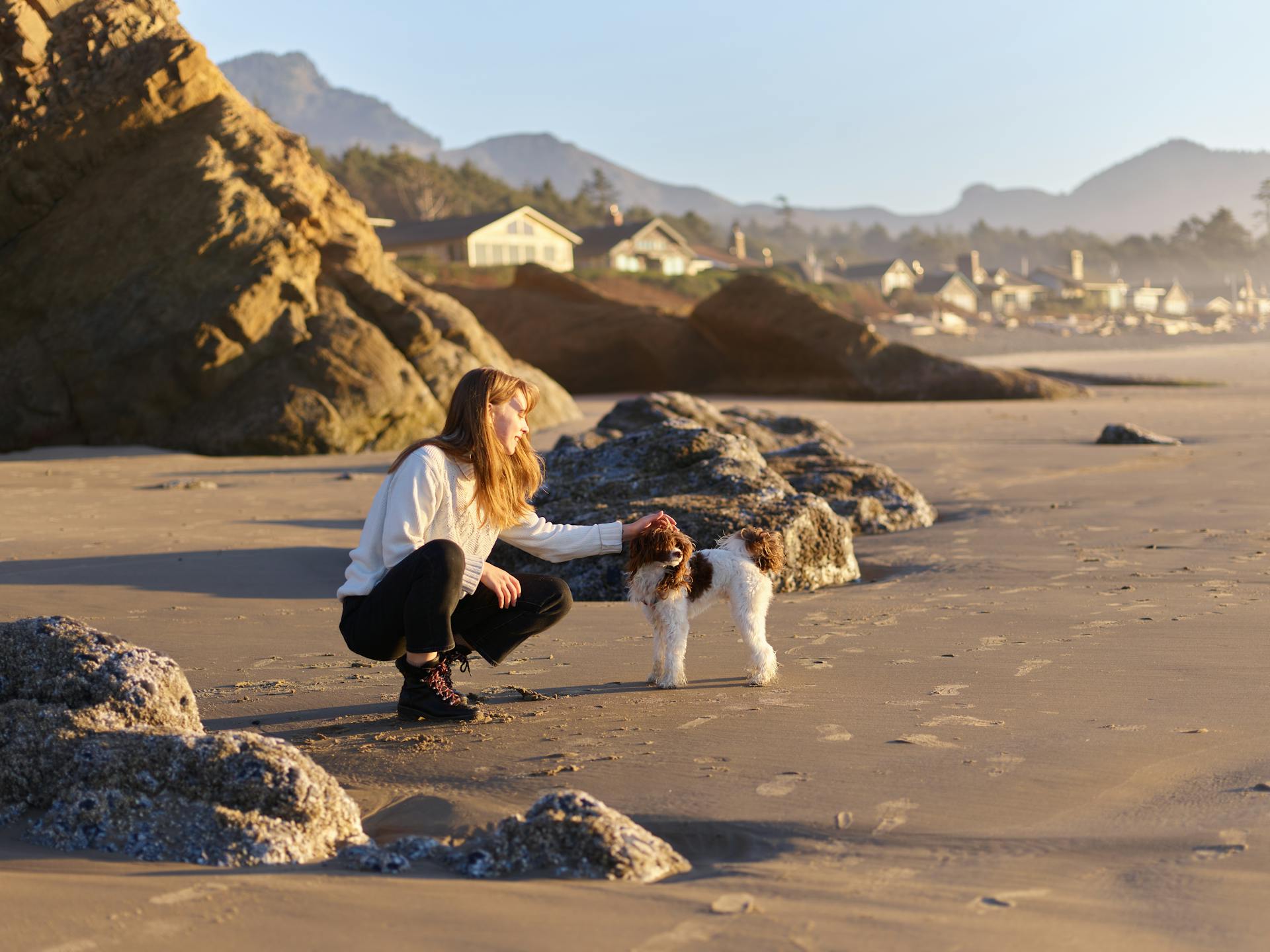 Woman in Crouching Position Petting Her Dog