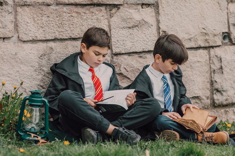 Boys In Black Robes Reading A Spell Book