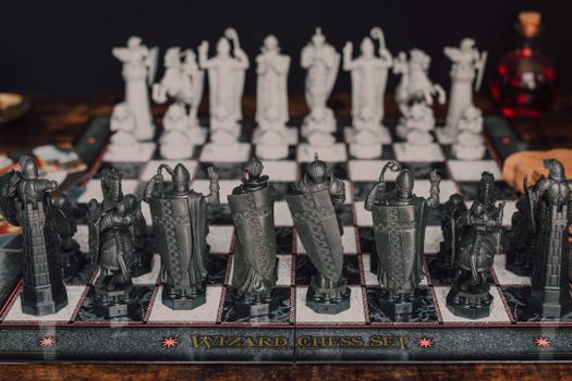 Close-up of a fantasy-themed wizard chess set featuring intricate black and white pieces.