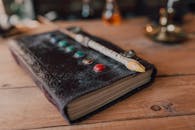 Close-Up Shot of a Spell Book and a Wand