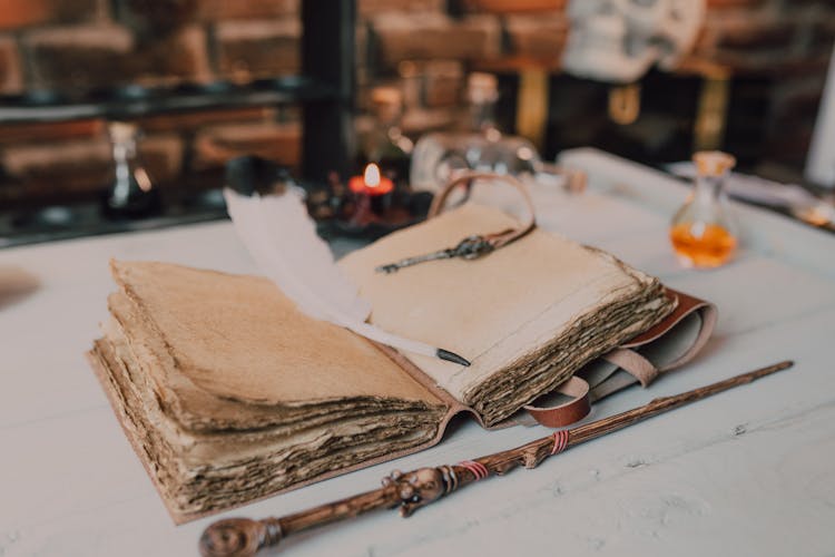 Close-Up Shot Of A Spell Book And A Wand