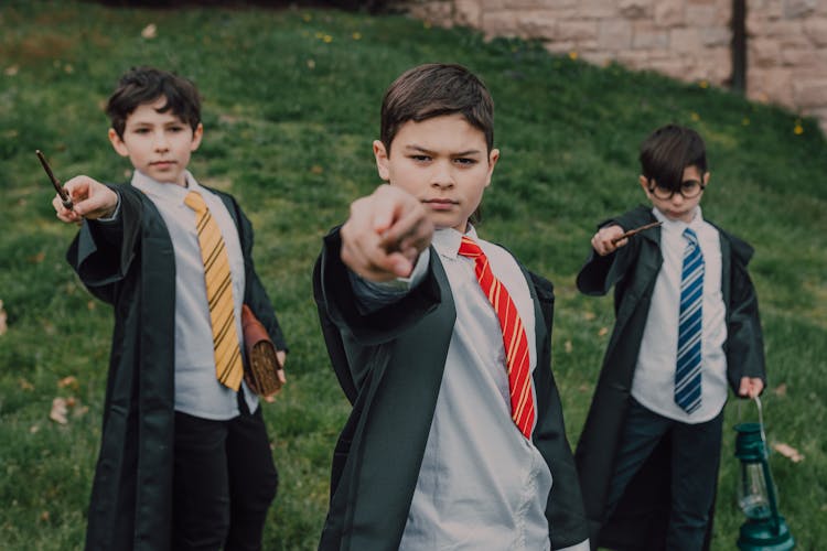 Boys In Black Robes Holding Wands