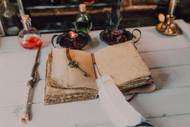 Close-Up Shot Of A Spell Book And A Wand