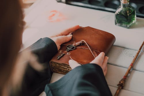 A Person Holding Brown Book