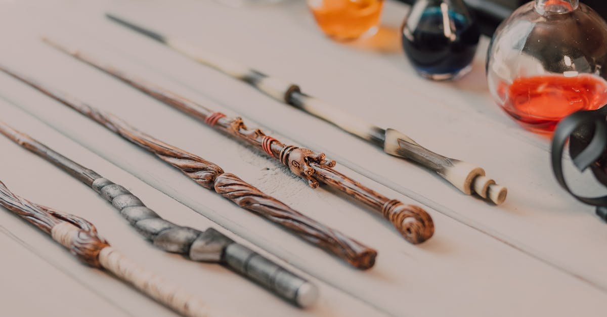 Close-up of magical wands and potion bottles on a wooden table, evoking fantasy.