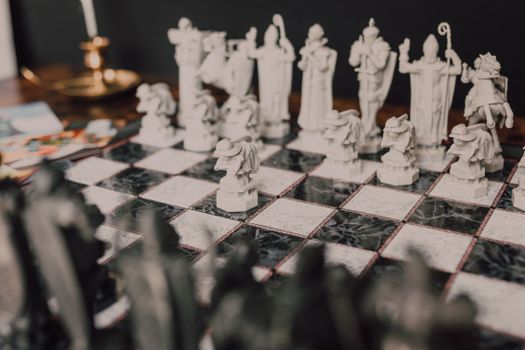 Stylized close-up of a themed chess set with unique, artistic figures on a marble board.