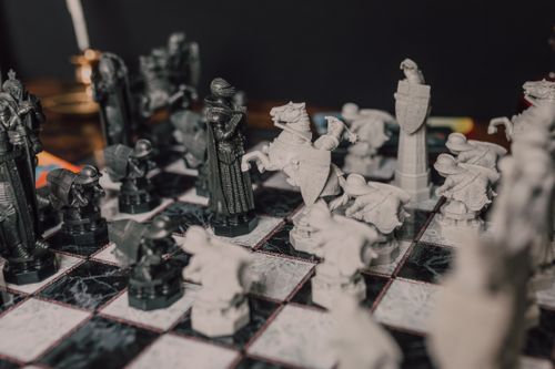 Free Close-up of ornate chess pieces on a classic marble chessboard, evoking a magical theme. Stock Photo