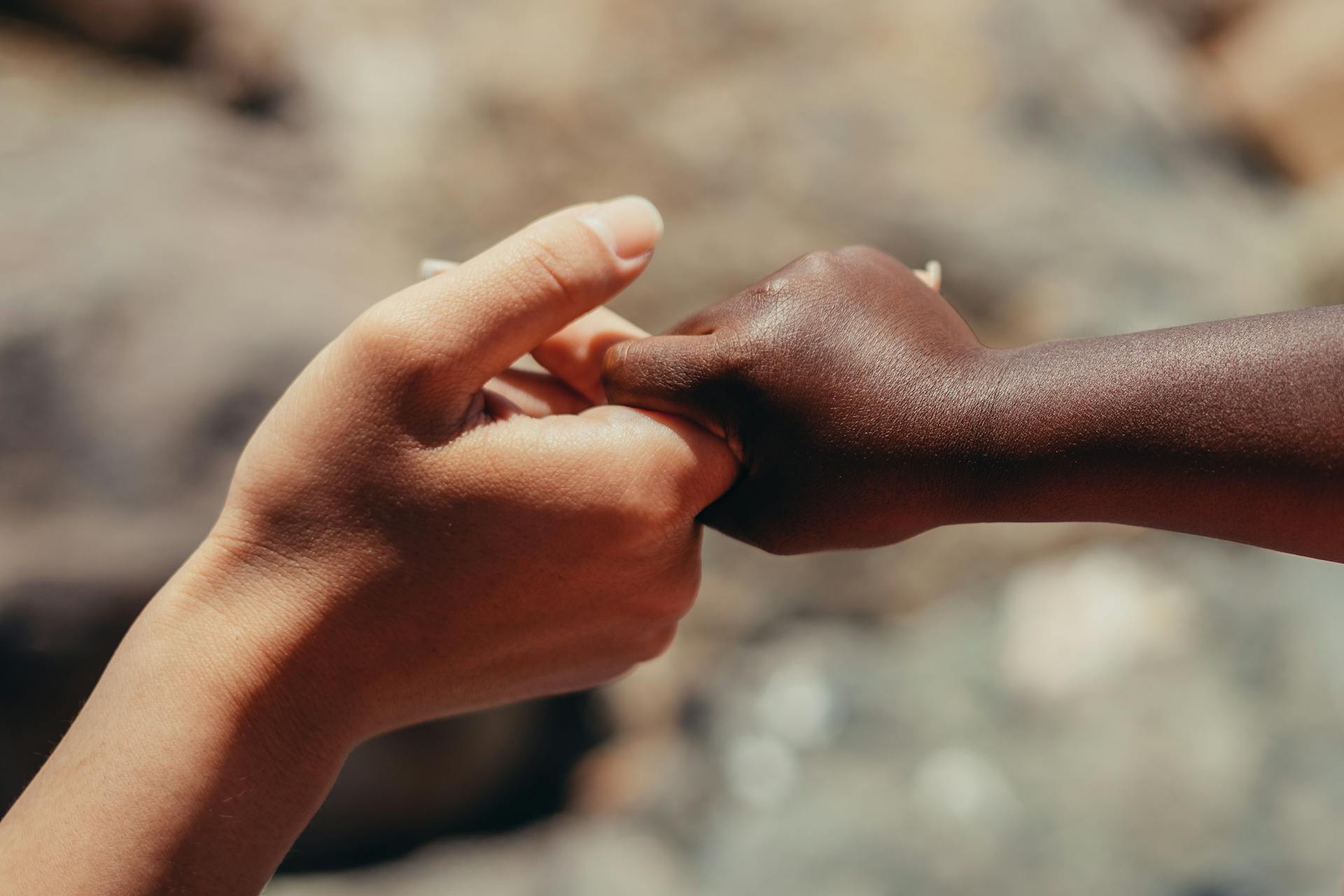 Close-up Photo of Two People holding each other's Hands