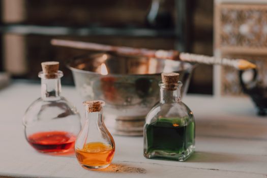 A mystical setup featuring colorful potions and a wizard's wand, evoking a fantasy theme.