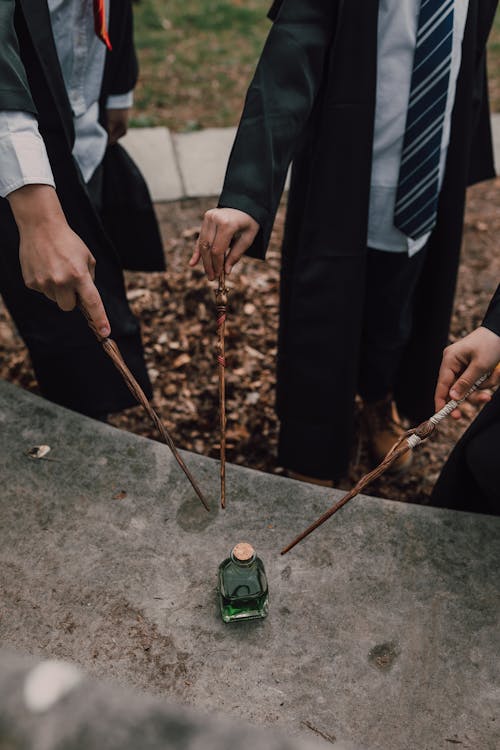 Children in Black Robes Holding Wands