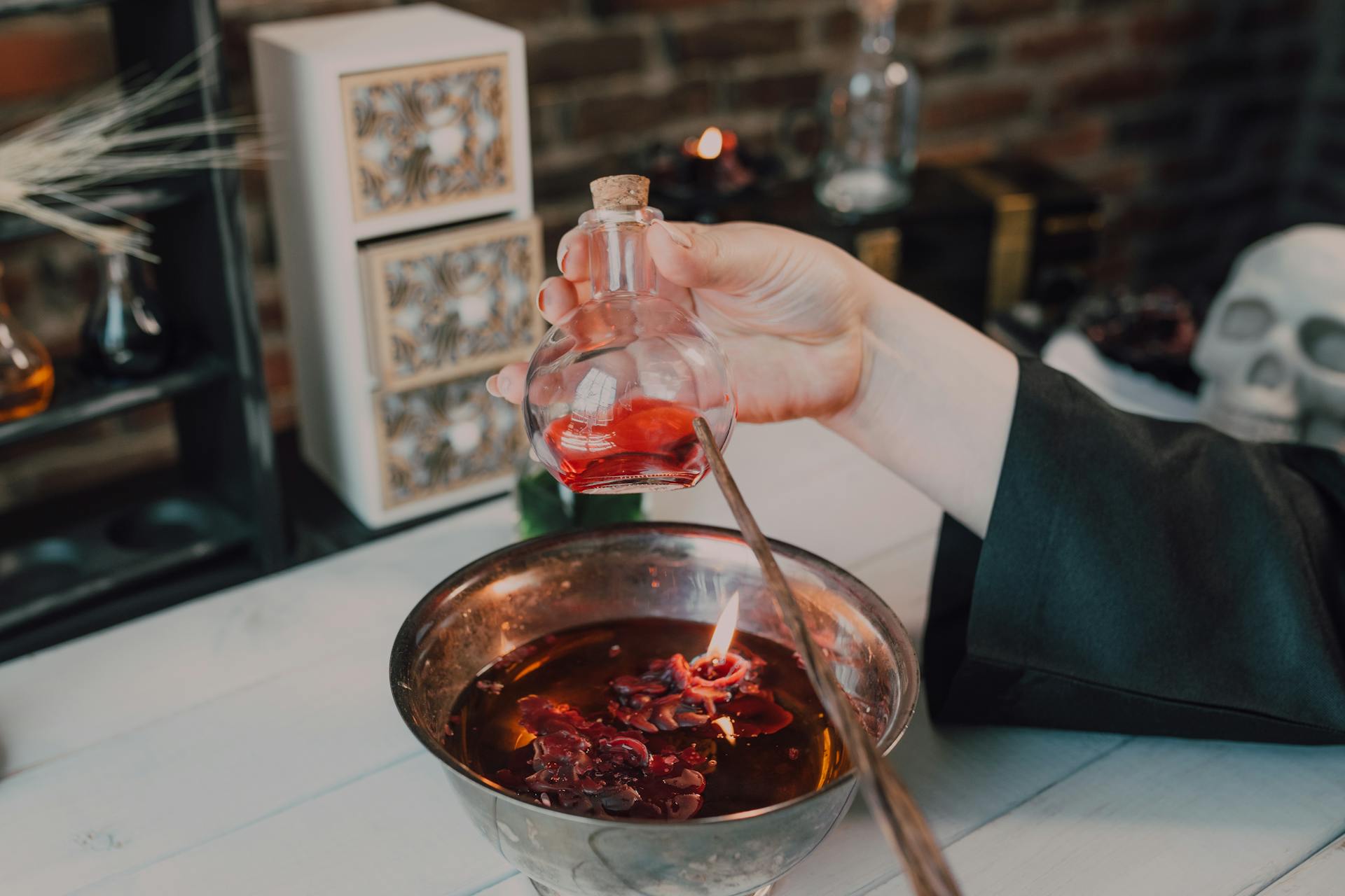 Close-Up Shot of a Person Holding a Wand and a Potion