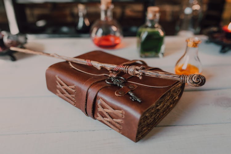 Close-Up Shot Of A Wand And A Spell Book