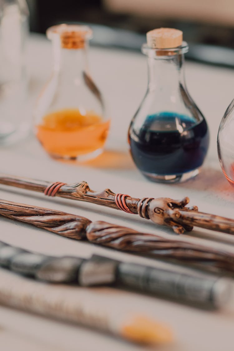 Close-Up Shot Of Wands Beside Potions