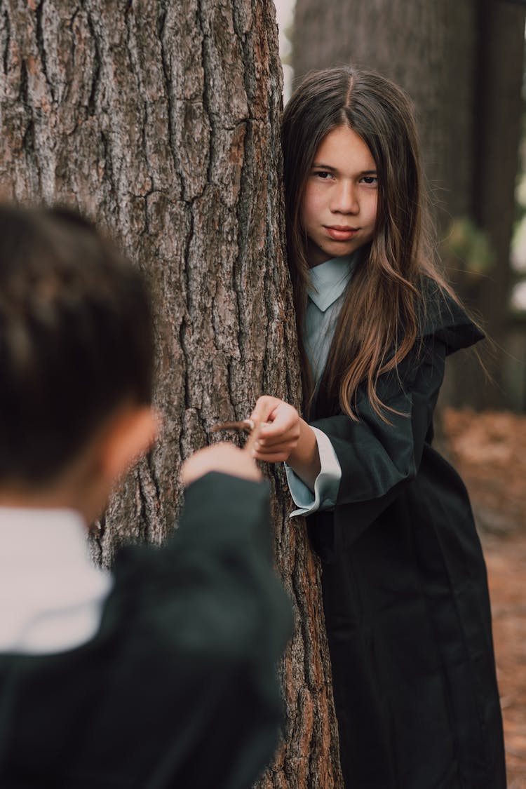 A Girl In Black Robe Holding A Wand 