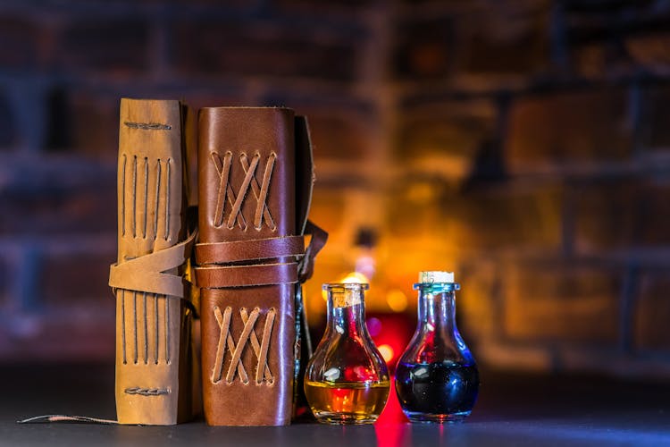 Close-Up Shot Of Spell Books Beside Potions