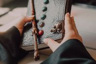 Hands with Medieval Leather Book and Wand