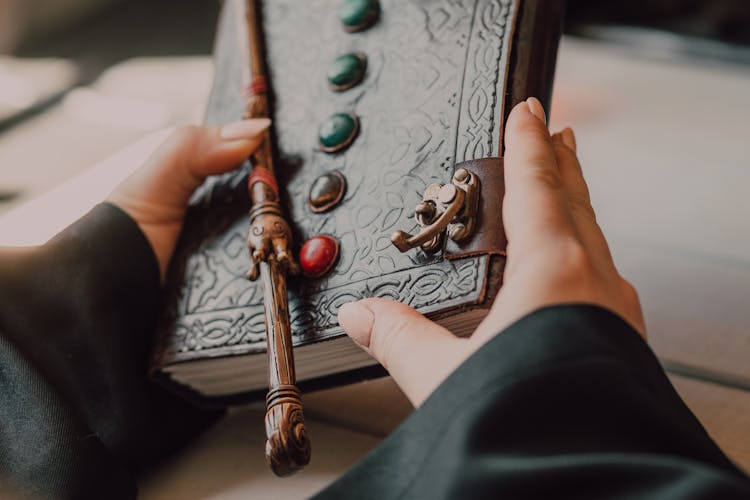 Hands With Medieval Leather Book And Wand