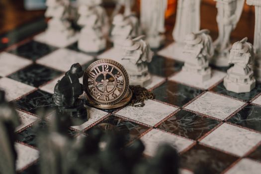 Close-up of a detailed chess set inspired by fantasy themes with a magical vintage clock on the board.