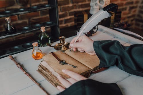 Close-Up Shot of a Person Writing on a Spell Book