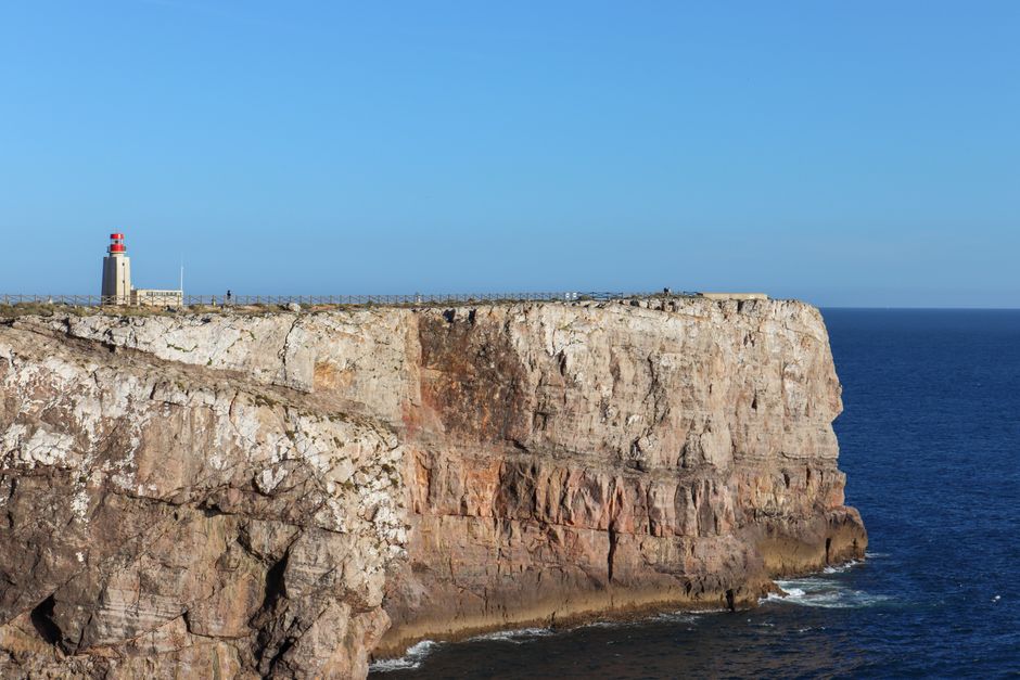 Stunning view of Sagres Point lighthouse on a rugged coastal cliff in Portugal.