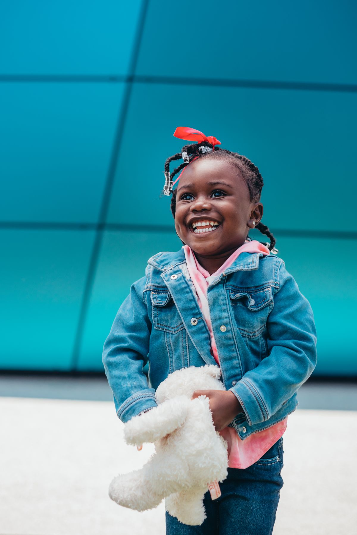 A smiling little girl in a denim jacket