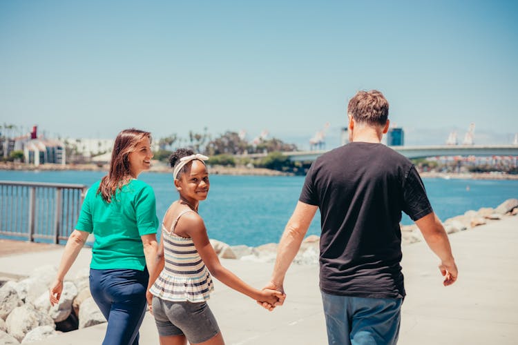 A Girl Walking With Her Parents 