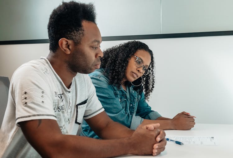 A Couple Reviewing A Document On The Table