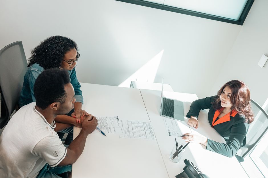 diverse couple meeting with a mortgage lender in San Diego office
