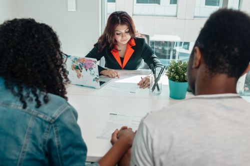 Free A couple discussing legal documents with a lawyer in a modern office environment. Stock Photo