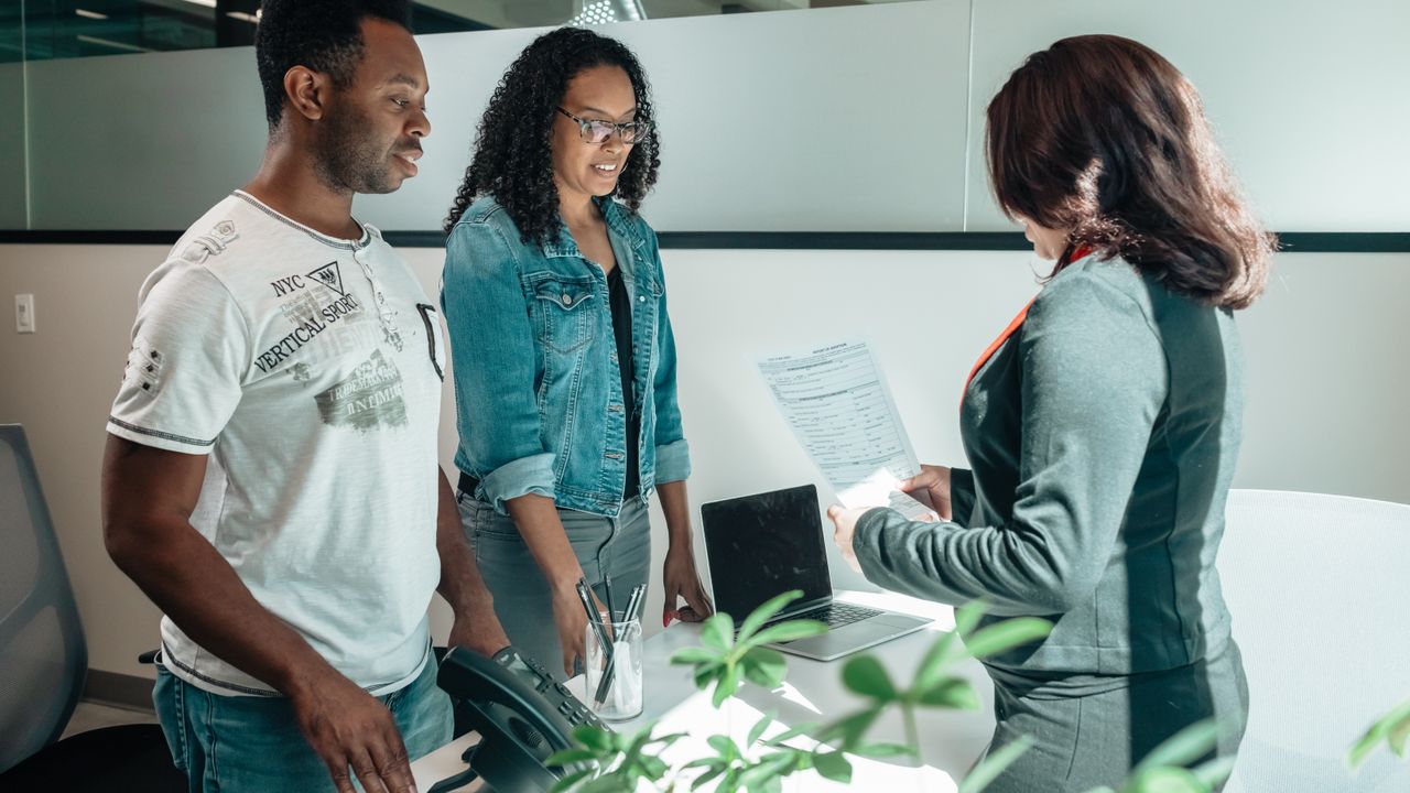 A diverse group in a business meeting discussing documents in a modern office setting.